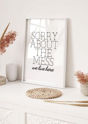 An unframed print of sorry about the mess quote in typography in white and black accent colour