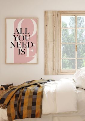 An unframed print of all you need is love quote in typography in pink and white accent colour