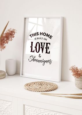 An unframed print of this house is built on love quote in typography in white and black accent colour