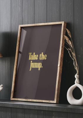 An unframed print of gold inspirational take the jump quote in typography in brown and black accent colour