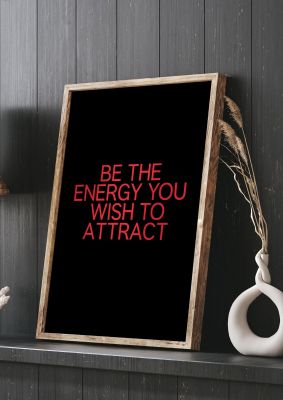 An unframed print of be the energy you wish to attract inspirational quote in typography in red and black accent colour